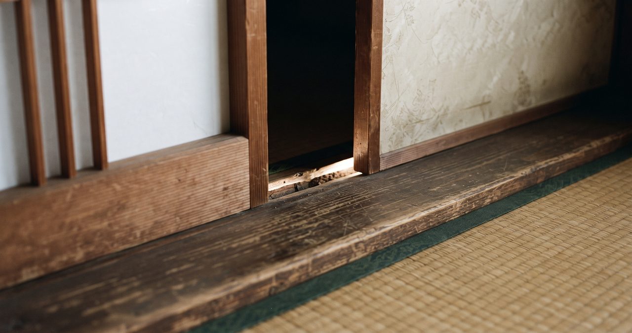 和室の障子とふすまの敷居部分に木枠のゆがみによる隙間ができており、そこから光が漏れている様子のクローズアップ